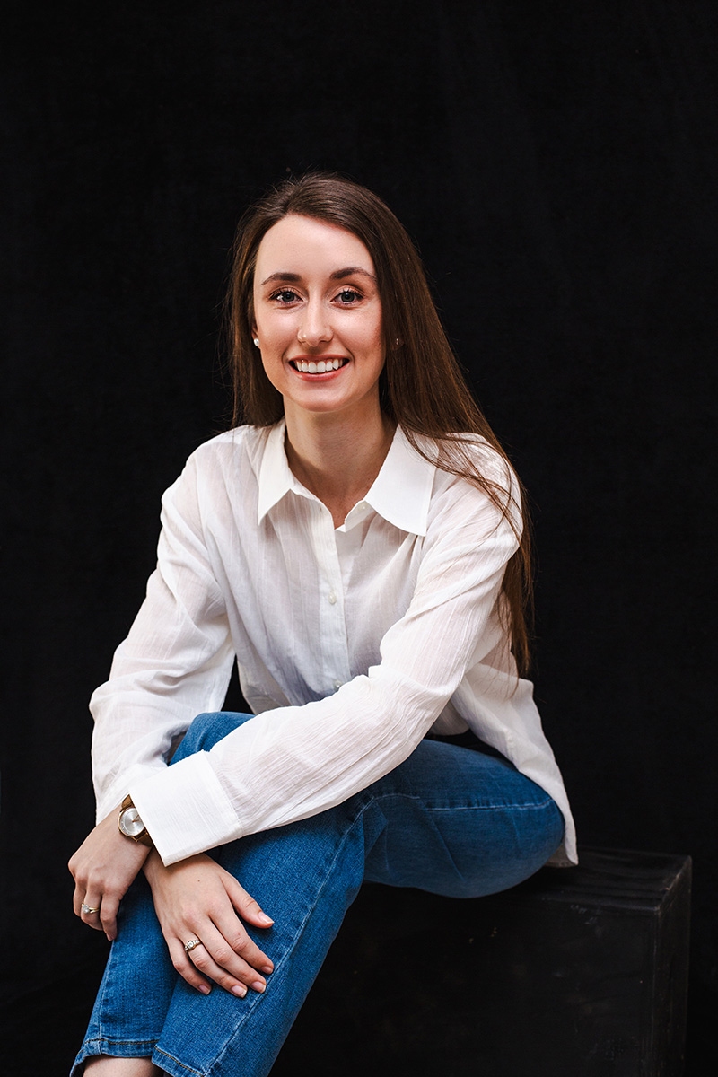 A business owner seated, smiling to camera