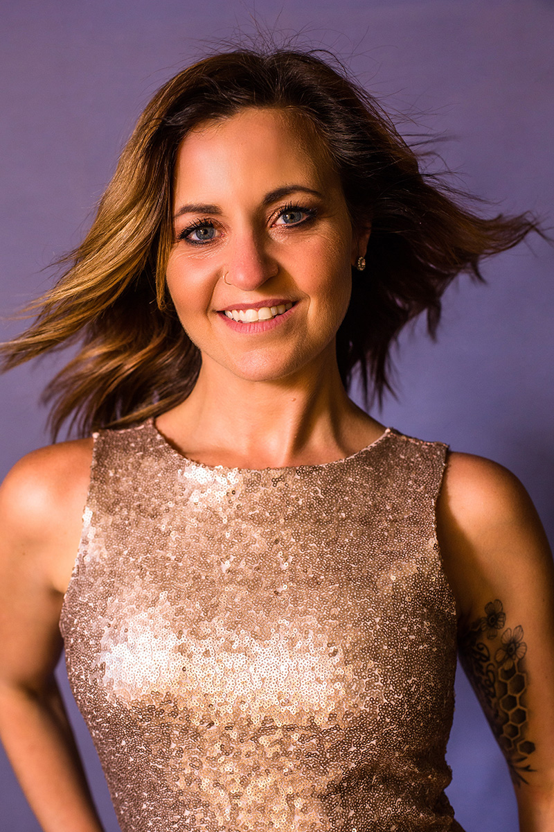 A client in a sequin dress, smiling to camera