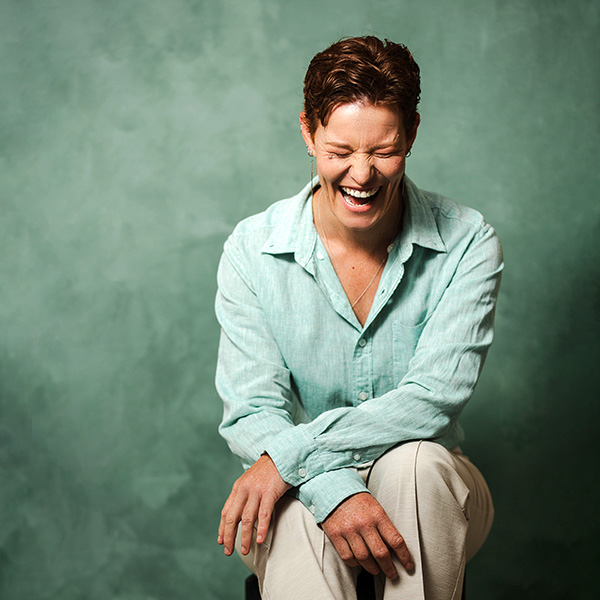 A client laughing on a green backdrop